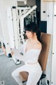 A woman sitting on a bench in a gym.