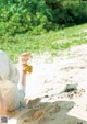 A woman sitting on the sand with her feet in the sand.