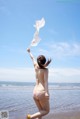 A woman in a bikini running on the beach.