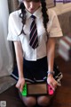 A woman in a school uniform holding a Nintendo Switch.