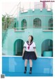 A woman in a school uniform standing in front of a building.