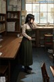 A woman standing in front of a desk in a library.